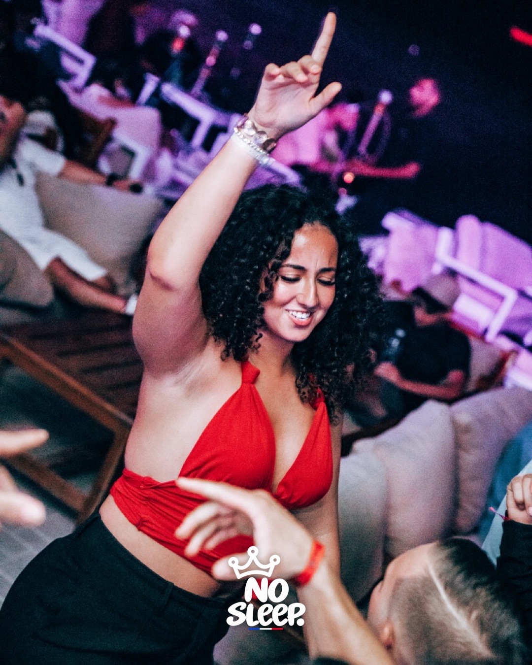 Une invitée en haut rouge danse le bras en l'air