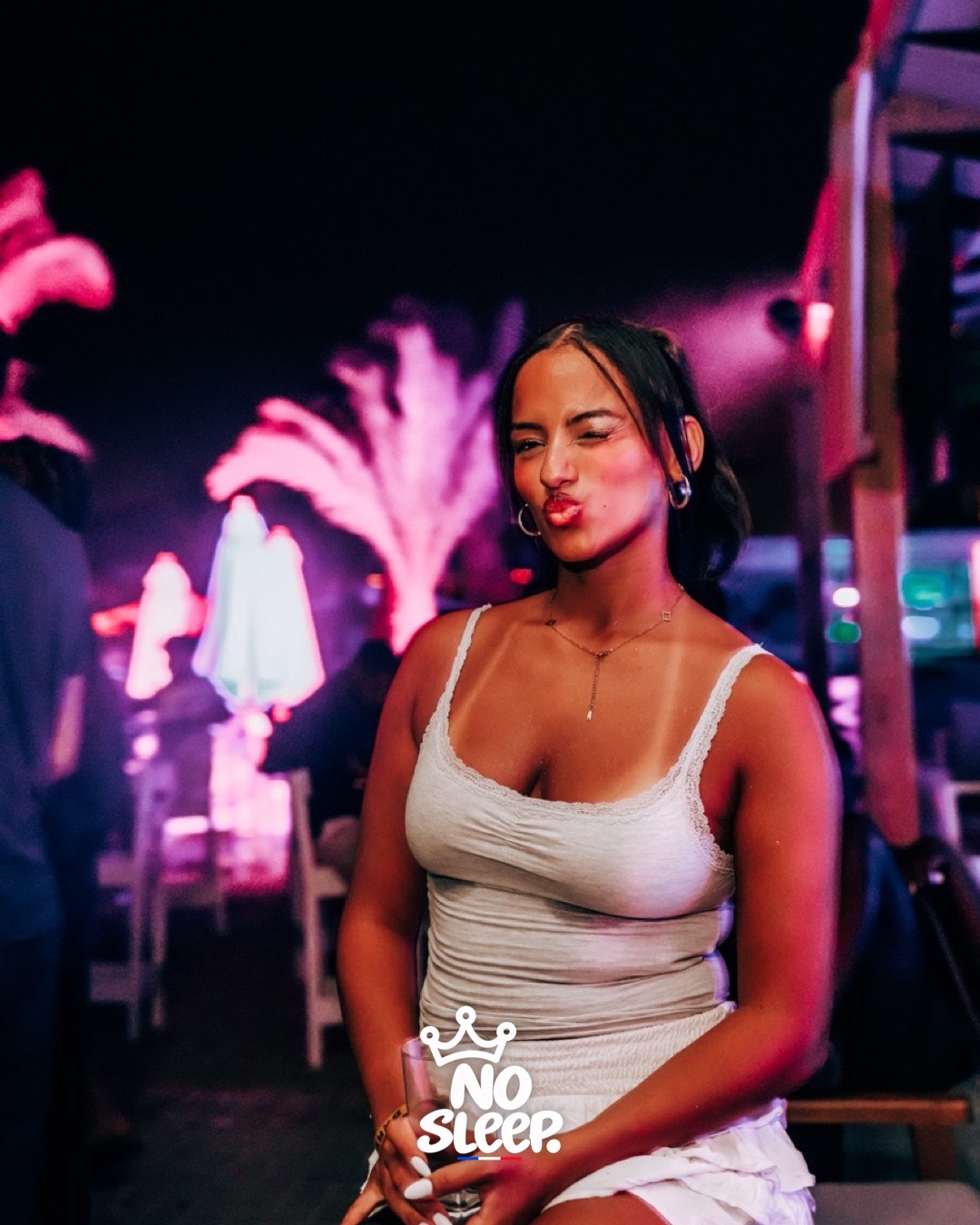 Une invitée en top blanc pendant la soirée plage