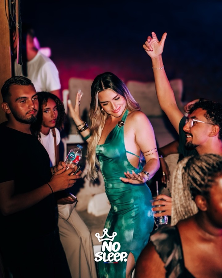 Une invitée en robe verte danse entourée d'amis