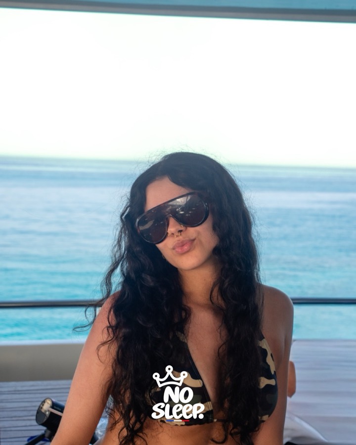 Une invitée en lunettes de soleil face à la mer